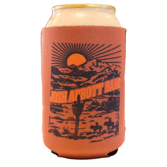 Orange can cooler with a desert landscape design featuring a sunset, mountains, and cactus.