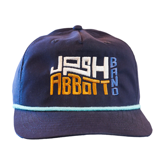Navy blue baseball cap with ’Josh Abbott Band’ embroidered in white, orange, and light blue lettering.